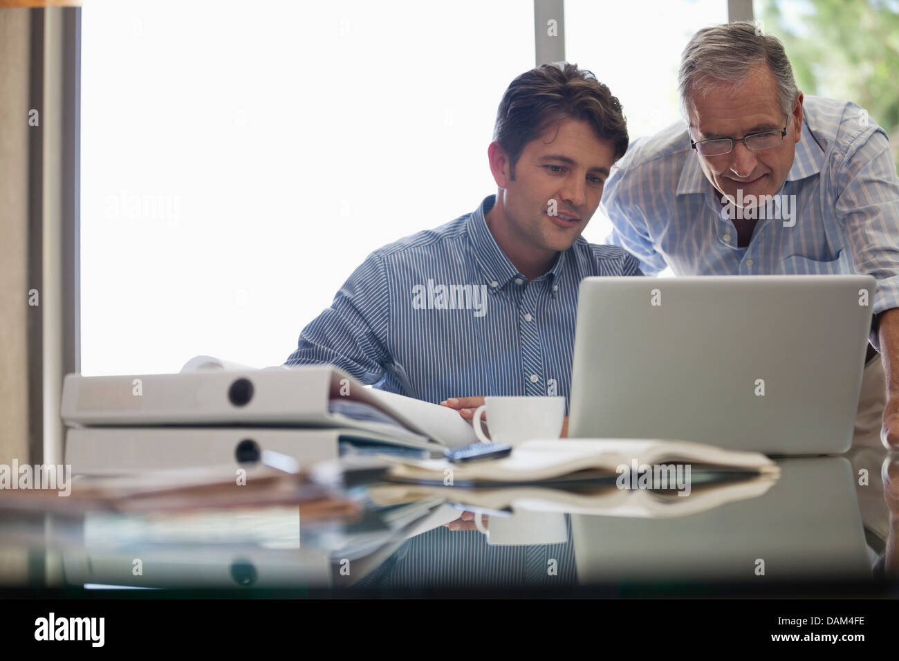Älterer Mann und jüngeren Mann zusammen arbeiten am Schreibtisch Stockfoto