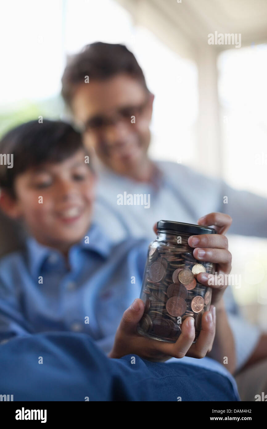 Vater und Sohn halten ändern Glas Stockfoto