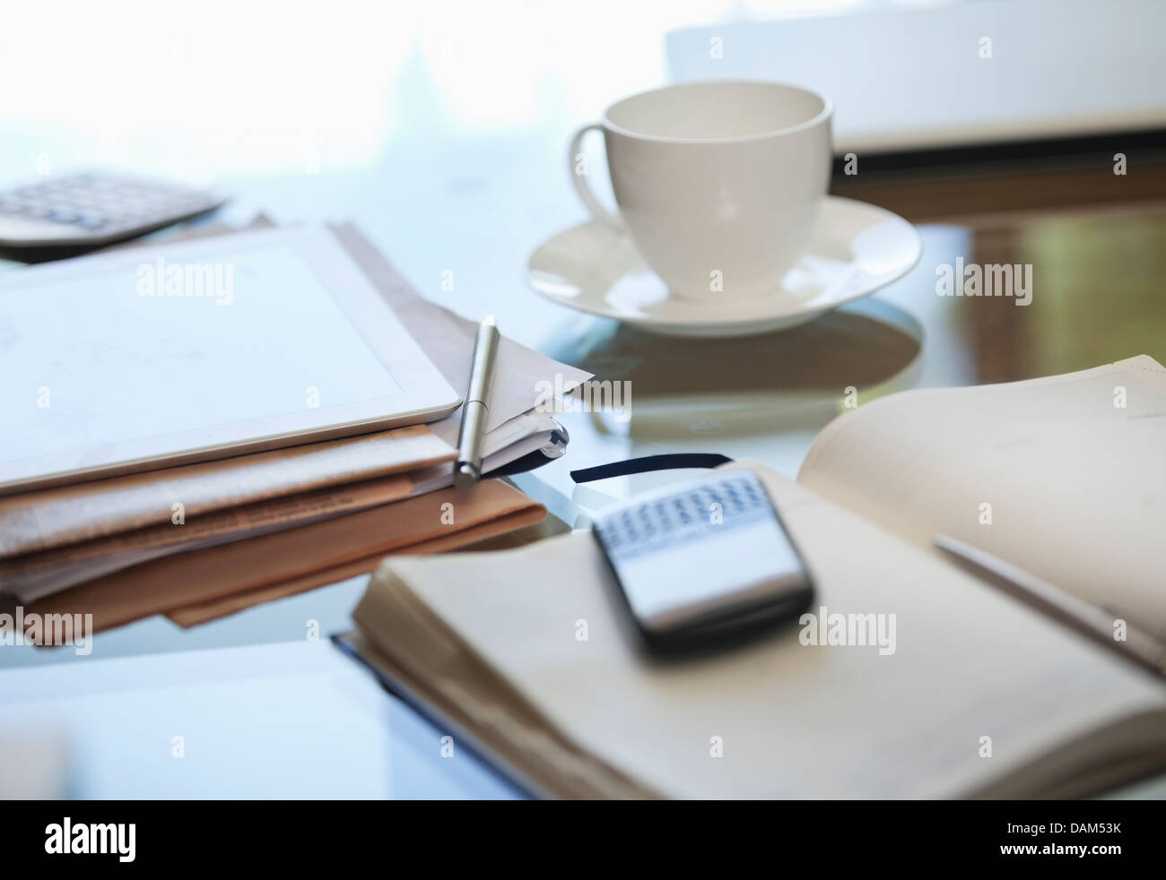 Notebook, Handy und Tasse Kaffee am Schreibtisch Stockfoto
