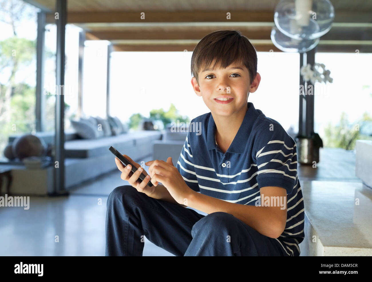 Junge mit Handy auf Treppe Stockfoto