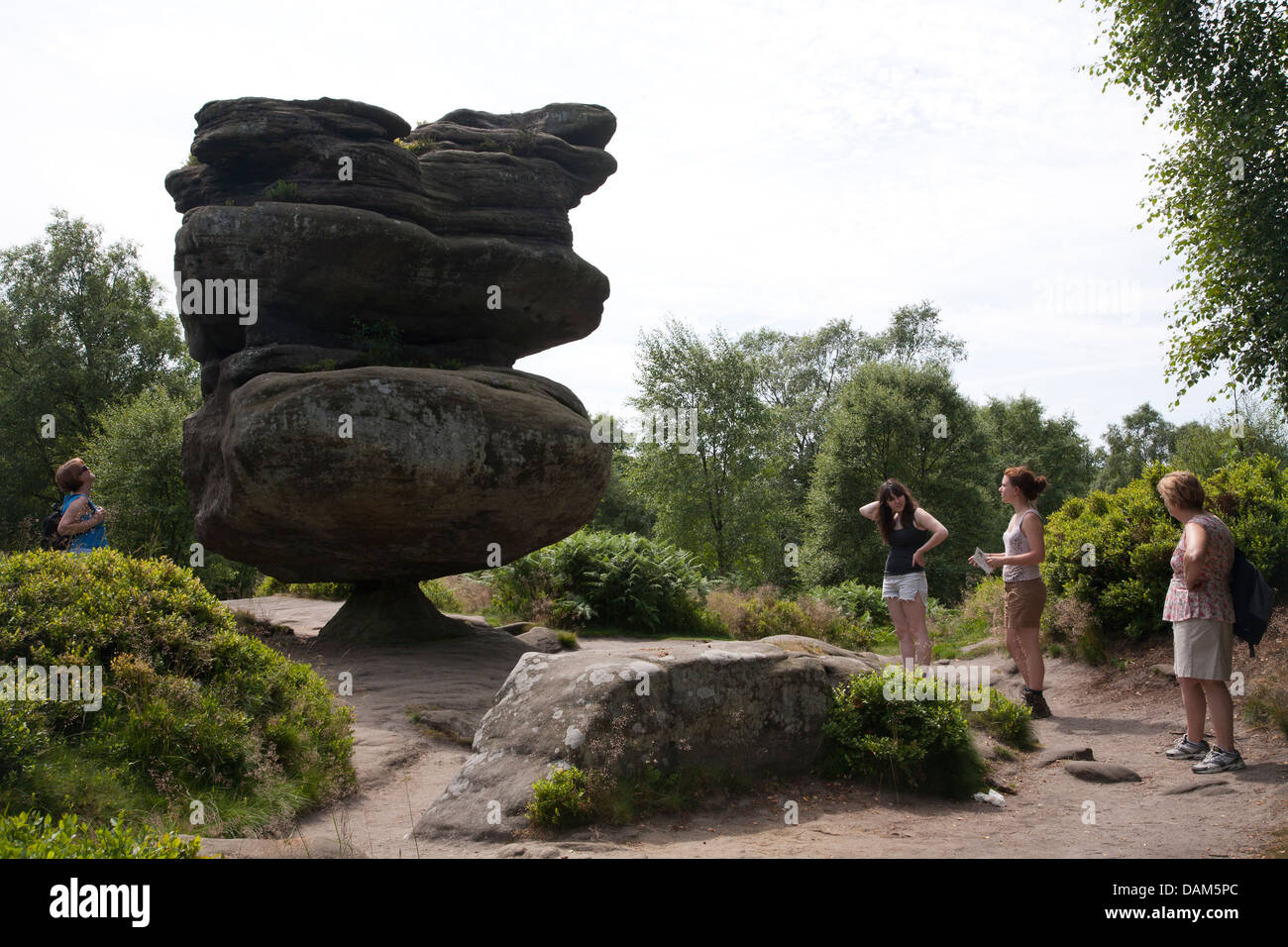 Vier Frauen betrachten die Idol-Rock. Brimham Rocks Stockfoto