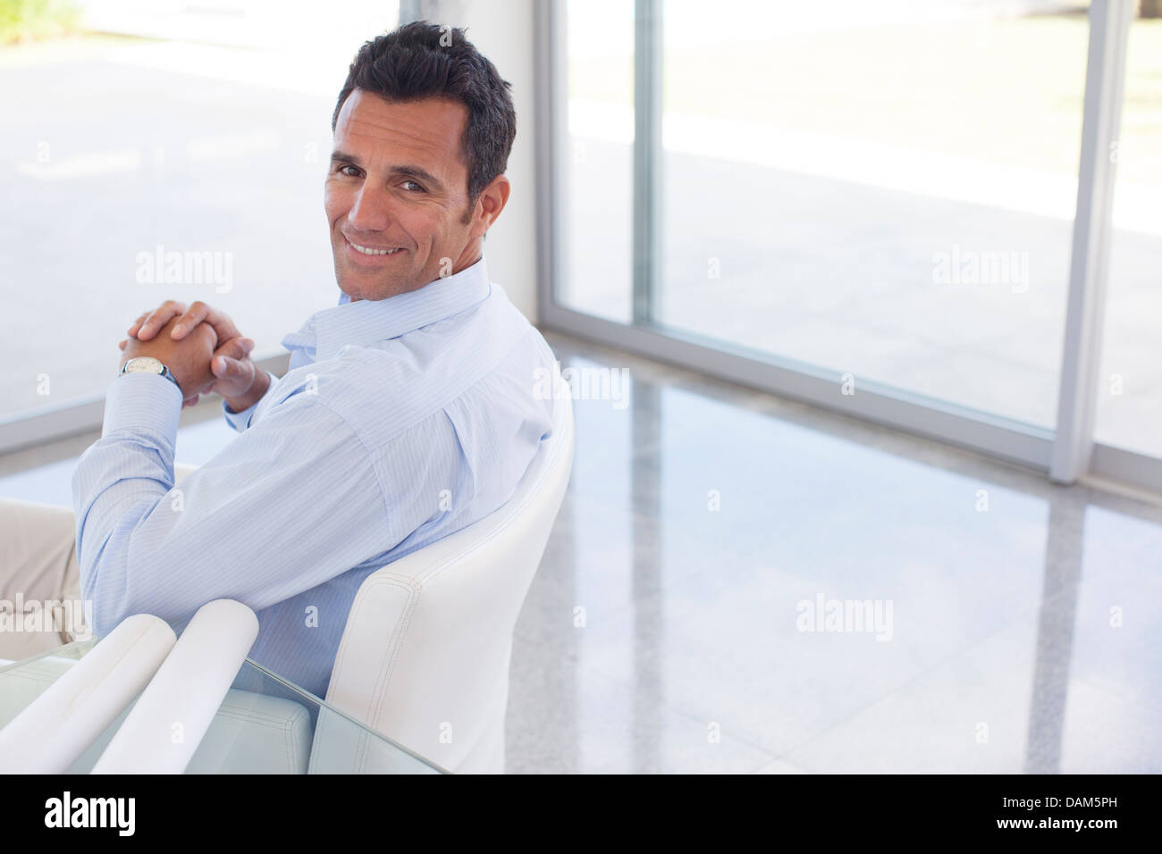 Geschäftsmann lächelnd in Bürostuhl Stockfoto
