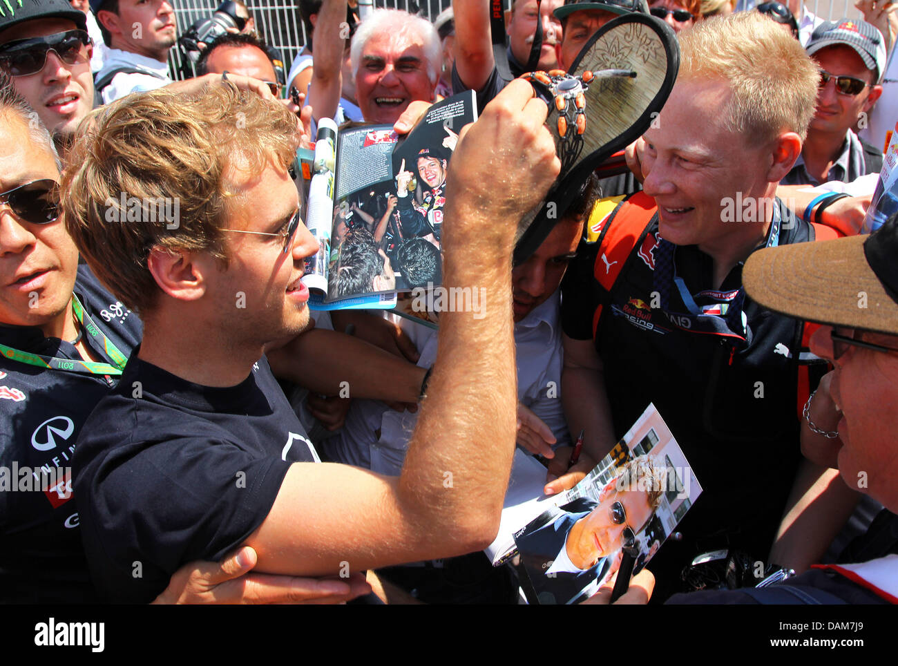 Deutsche Formel1-Fahrer Sebastian Vettel von Red Bull hebt eine Sandale im Fahrerlager an der F1 Rennstrecke von Monte Carlo, Monaco, 27. Mai 2011. Der Schuh war einen Autogramm Sammler in der Menge verloren. Der Grand Prix wird am 29 Mai stattfinden. Foto: Jens Buettner dpa Stockfoto
