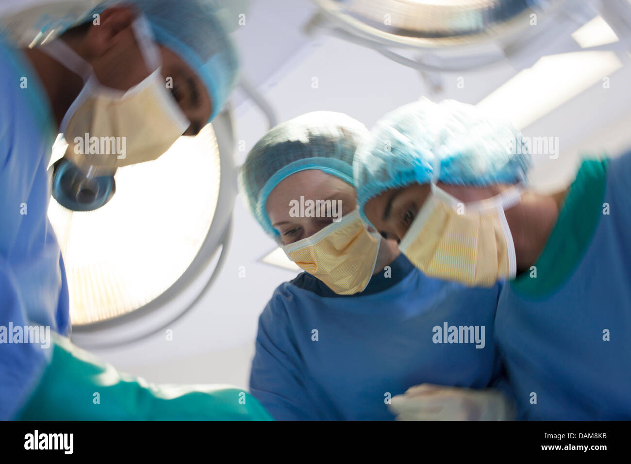 Chirurgen, beugte sich über Patienten im OP-Saal Stockfoto