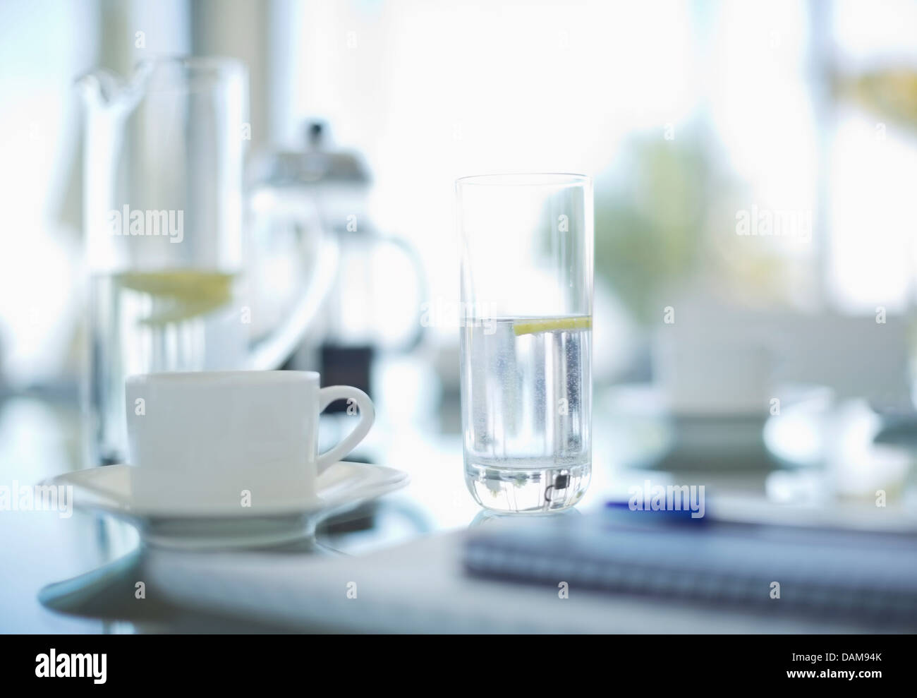 Kaffeetassen und Wassergläser auf Besprechungstisch Stockfoto