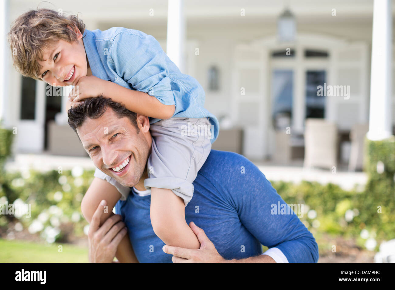 Vater und Sohn spielen vor Haus Stockfoto
