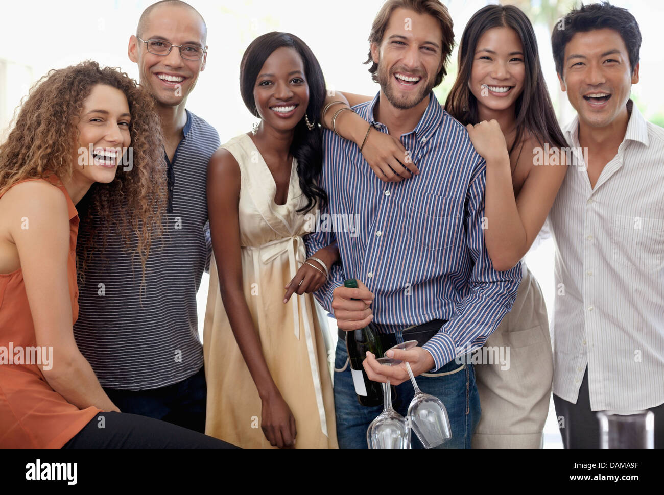 Freunde lächelnd zusammen auf party Stockfoto