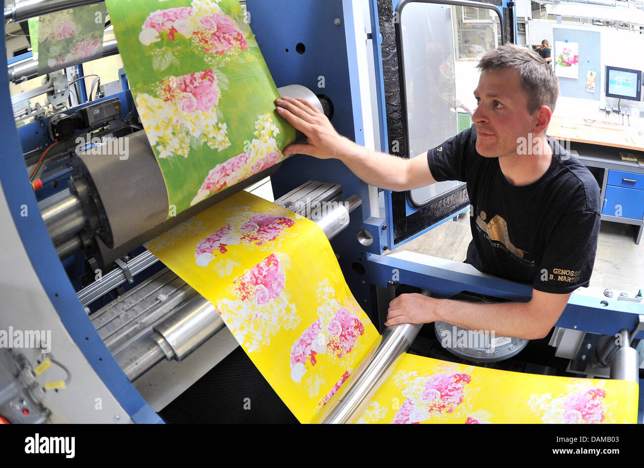 Ein Drucker prüft Blatt bedruckte Servietten auf die Leistungen von Paper +  Design GmbH in Wolkenstein, Deutschland, 18. Mai 2011. Das sächsische  Unternehmen produziert Papiertischdecken und Servietten für Kunden in 80  Ländern