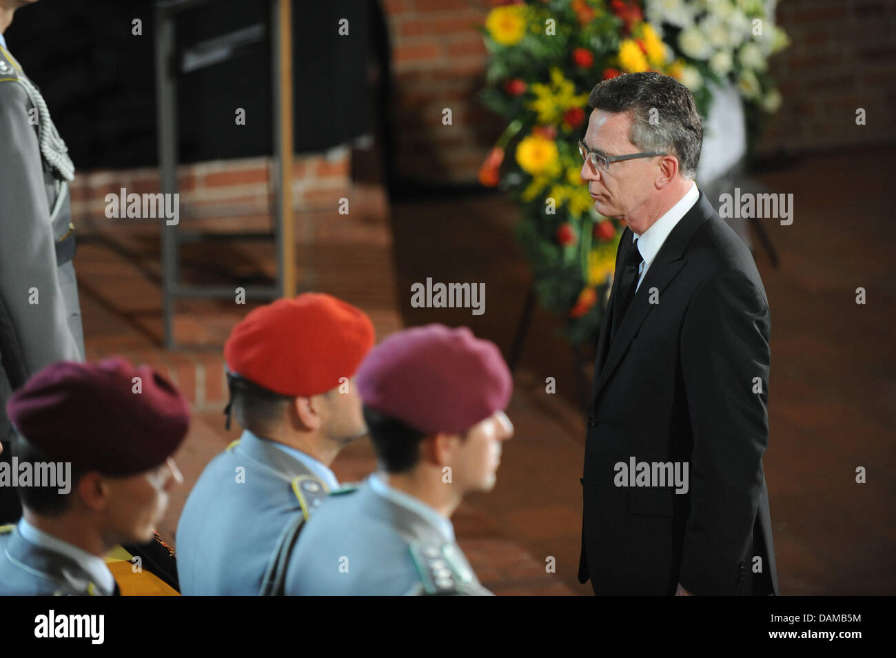 German Defence Minister Thomas de Maiziere (R) steht vor Särge von drei Soldaten der Bundeswehr, die während ihrer Mission in Afghanistan während einer Trauerfeier in der Epiphanias-Kirche in Hannover, 3. Juni 2011 gestorben. Die Bundeswehr Abschied von den Soldaten, die während eines Angriffs in Afghanistan in der Vorwoche starb. Foto: PETER STEFFEN Stockfoto