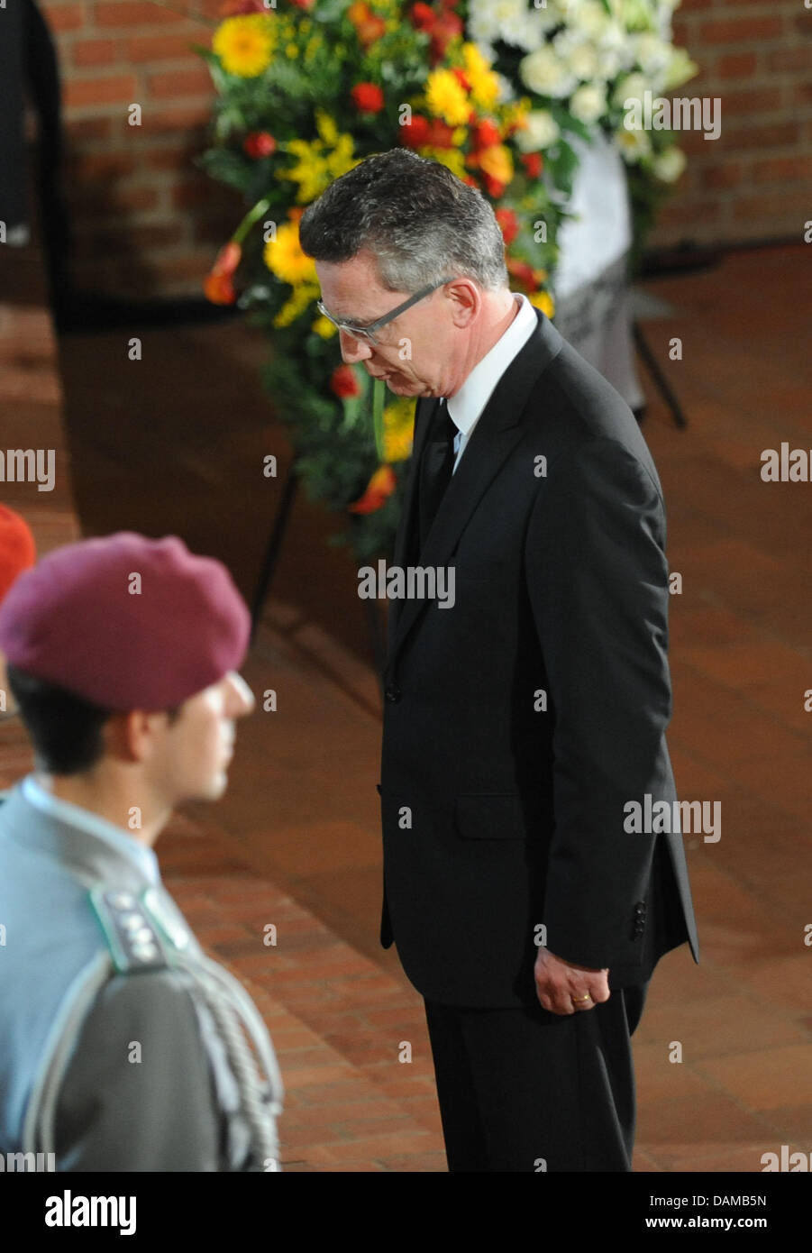 German Defence Minister Thomas de Maiziere (R) steht vor Särge von drei Soldaten der Bundeswehr, die während ihrer Mission in Afghanistan während einer Trauerfeier in der Epiphanias-Kirche in Hannover, 3. Juni 2011 gestorben. Die Bundeswehr Abschied von den Soldaten, die während eines Angriffs in Afghanistan in der Vorwoche starb. Foto: PETER STEFFEN Stockfoto