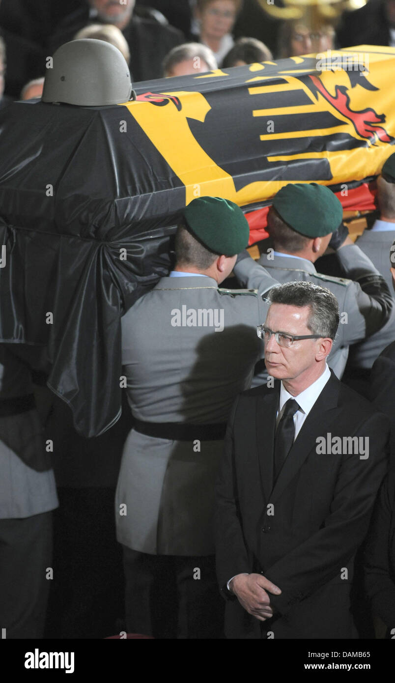 German Defence Minister Thomas de Maiziere (Front-R) steht immer noch wie die Särge von drei Soldaten der Bundeswehr, die während ihrer Mission in Afghanistan starb während einer Trauerfeier in der Epiphanias-Kirche in Hannover, 3. Juni 2011 weggetragen werden. Die Bundeswehr Abschied von den Soldaten, die während eines Angriffs in Afghanistan in der Vorwoche starb. Pho Stockfoto