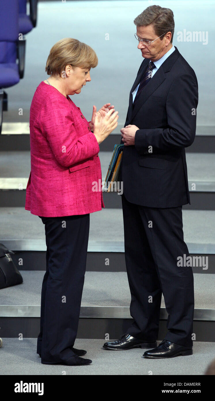 Bundeskanzlerin Angela Merkel spricht mit Foreign Minister Guido Westerwelle (R) im Bundestag in Berlin, Deutschland, 9. Juni 2011. Früher machte Bundeskanzlerin Merkel eine Regierungs-Anweisung auf Energiepolitik. Foto: Doreen Fiedler Stockfoto