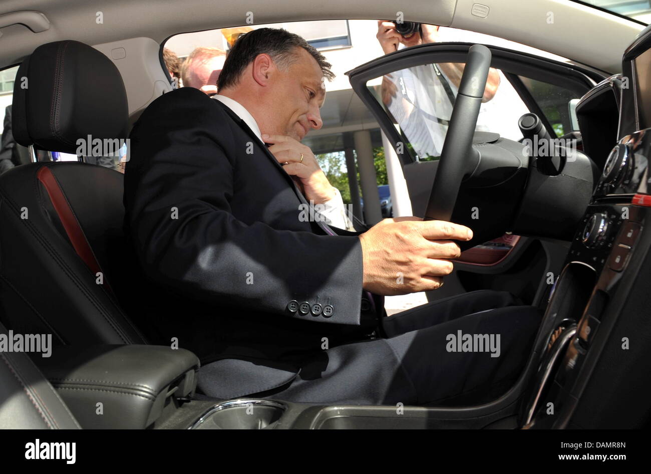 Ungarns Ministerpräsident Viktor Orban sitzt im Inneren ein Opel Ampera Elektroauto während seines Besuchs in Opel in Rüsselsheim, Deutschland, 28. Juni 2011. Opel investiert 500 Millionen Euro in ein neues Motorenwerk in der Süd-ungarische Opel-Basis in Szentgotthárd. Vor seinem Besuch Orban sprach über die EU-Ratspräsidentschaft an der Konrad-Adenauer-Stiftung in Hannover. Foto: Arne Dedert Stockfoto