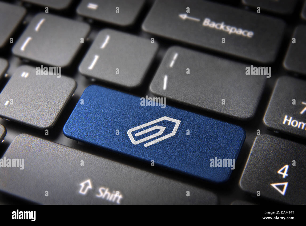 Büroklammer Dateischlüssel mit Anlagensymbol auf Laptop-Tastatur. Im Preis inbegriffen Clipping-Pfad, so dass Sie leicht bearbeitet werden kann. Stockfoto