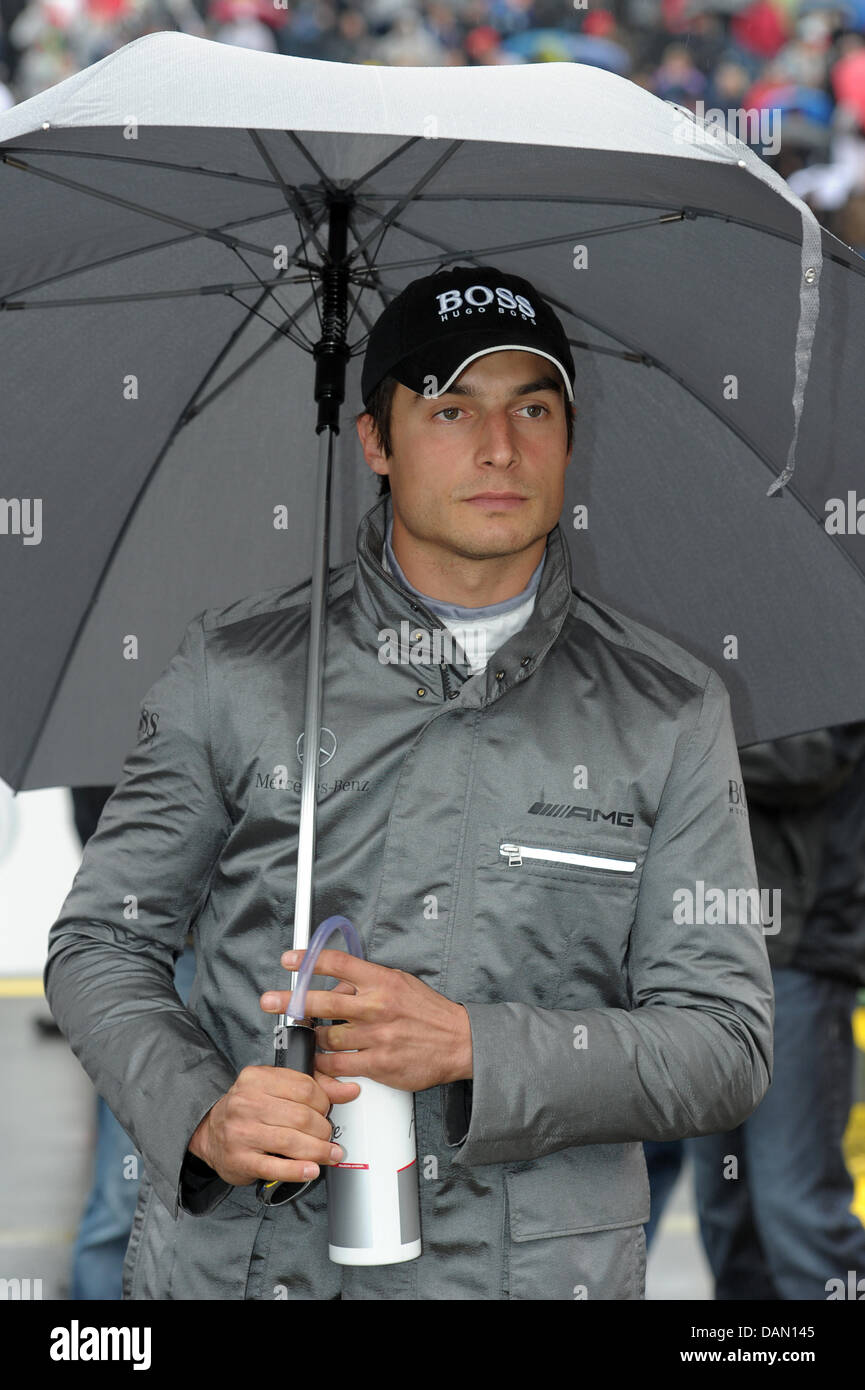 Der kanadische Deutsche Tourenwagen Masters-Fahrer Bruno Spengler  (Mercedes-Benz Bank AMG) steht unter einem Regenschirm vor dem Rennen auf  dem Norisring in Nürnberg, 3. Juli 2011. Spengler gewann das fünfte Rennen  der Deutschen