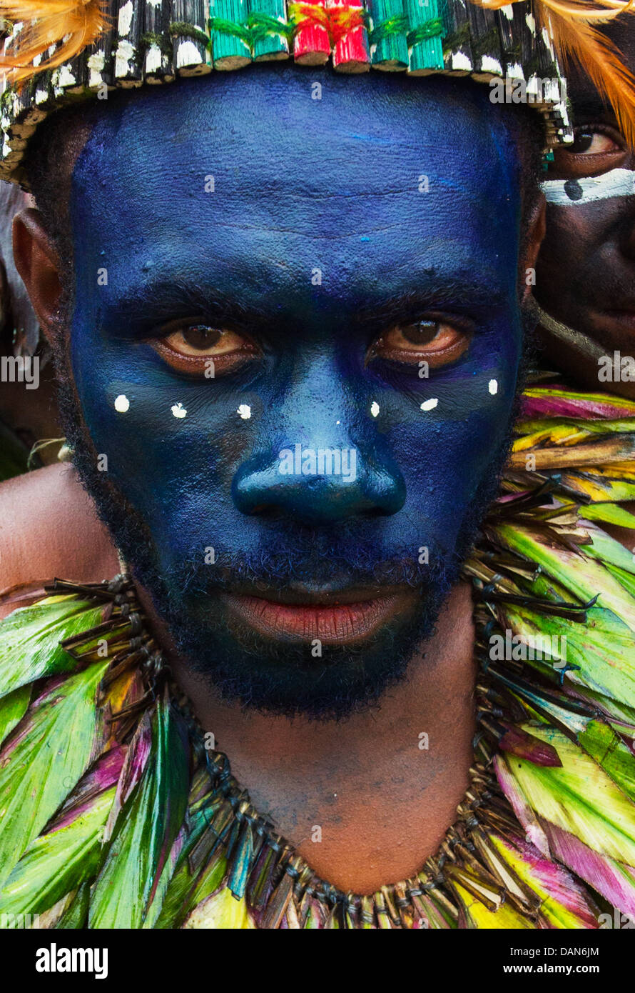 Tribal Mann mit seinem Gesicht in blauer Farbe lackiert und trägt eine Halskette aus Federn auf dem Goroka Festival in Papua-Neu-Guinea Stockfoto