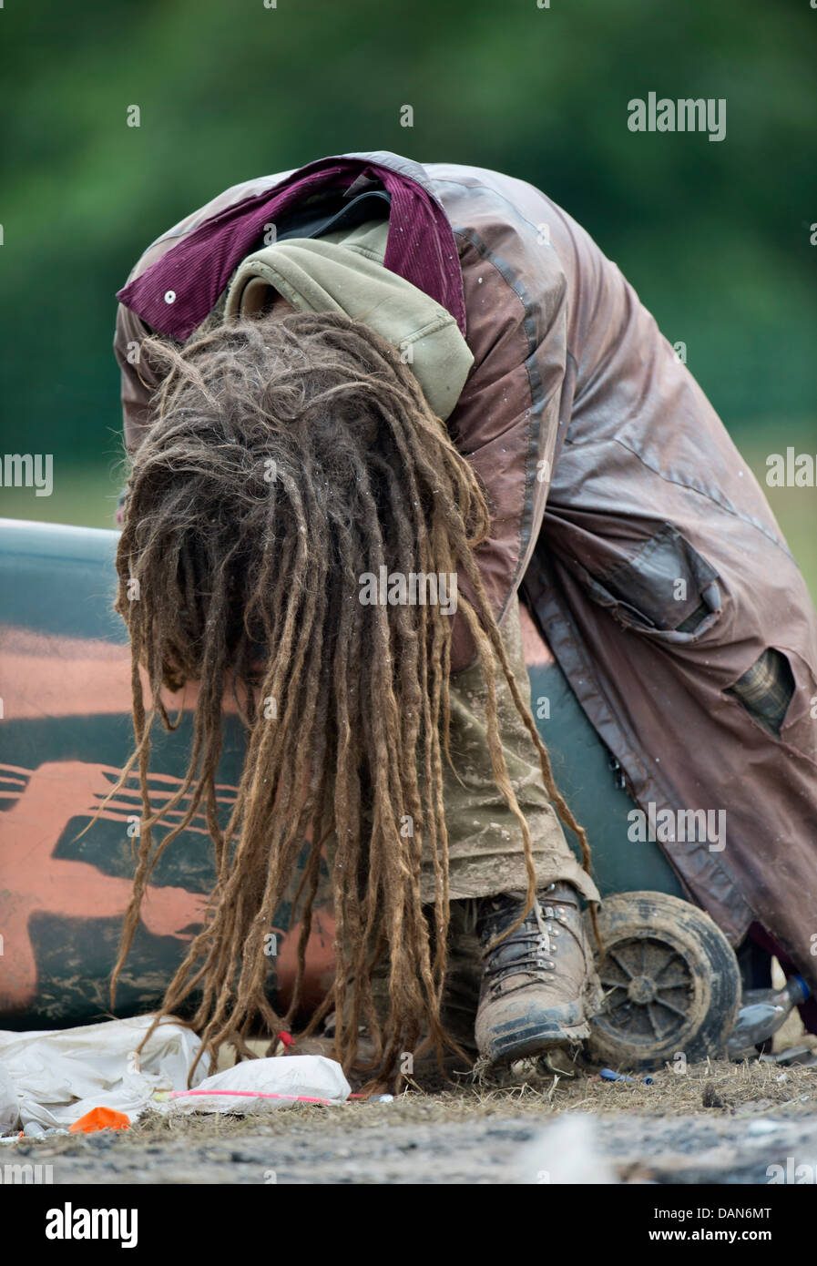 Glastonbury 2013 - Rastalocken einheimischer schläft auf einem umgedrehten Wheelie-bin am Steinkreis. Stockfoto