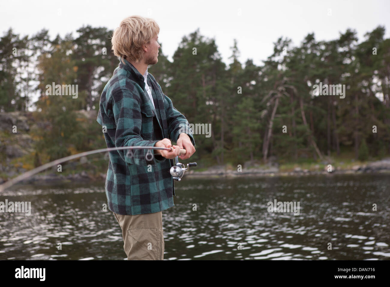 Schweden, junger Mann mit Angelrute, wegschauen Stockfoto