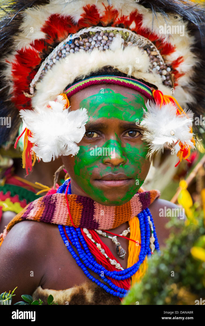 Porträt eines jungen Mädchens mit ihrem Gesicht grün lackiert und tragen eine traditionelle Kopfbedeckung auf der Goroka Show in Papua-Neu-Guinea. Stockfoto