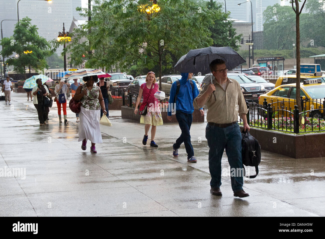 Fußgänger zu Fuß durch Regendusche. Michigan Avenue, Chicago, Illinois Stockfoto