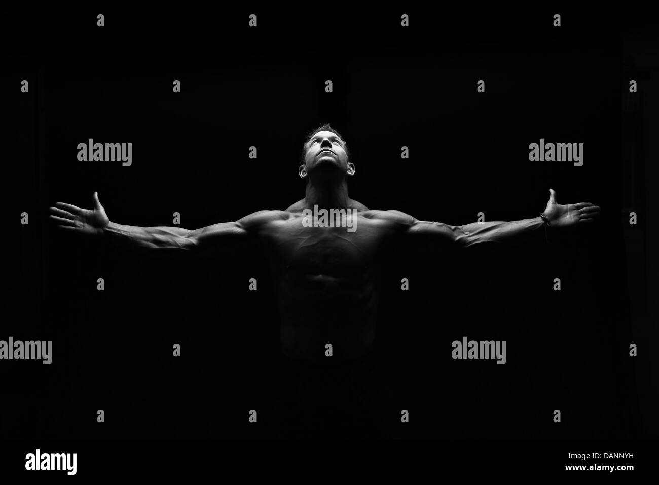 Starke Fitness Mann blickte mit Armen verteilt. Stockfoto
