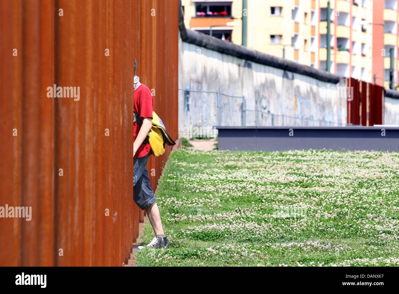 Ein Tourist geht "durch" die Mauer an der Bernauer Straße (Bernauer Straße) in Berlin, Deutschland, 12. Juli 2011. Um den Verlauf der Mauer zeigen, füllen gleich hohen Eisenstangen die Löcher. 13. August 2011 markiert den 50. Jahrestag des Baus der Berliner Mauer. Foto: Wolfgang Kumm Stockfoto