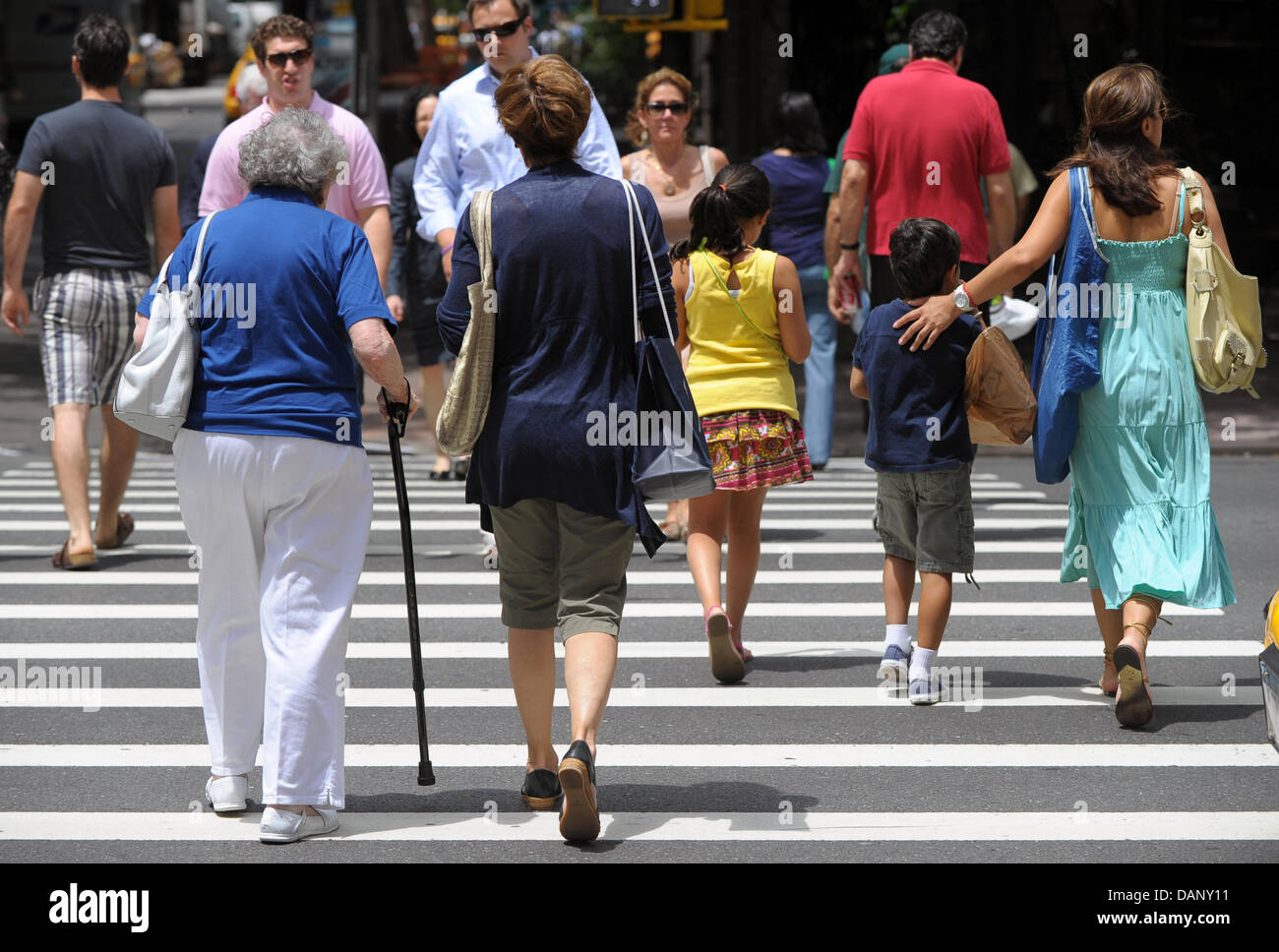 Fußgänger überqueren Lexington Avenue in Manhattan, New York, USA, 13. Juli 2011. US-Präsident Barack Obama ringt mit Kongreßführer über ein Abkommen über die Schulden des Landes. Wenn das Problem nicht bis 2. August 2011 gelöst ist, ist es nicht garantiert, dass eine geschätzte 50 Millionen prüft für Rentner, pensionierte Militärs, Behinderte und andere Regierung Begünstigten werden g Stockfoto