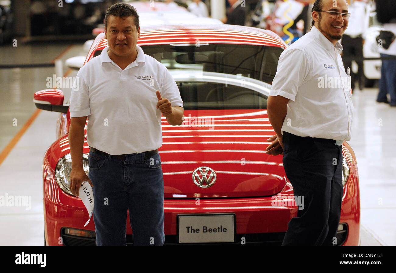 Ein Arbeiter Gesten vor dem ersten neuen Käfer-Auto, das später in Anwesenheit von Bundesaußenminister Guido Westerwelle und Mexikos Präsident Felipe Calderón Hinojosa im VW-Werk in Puebla, Mexiko, 15. Juli 2011 zusammengebaut werden. Westerwelle besucht das VW-Werk im Rahmen seines Besuchs in Mexiko. Er besucht auch die archäologische Ausgrabungsstätte Teotihuacan. Foto: MIC Stockfoto