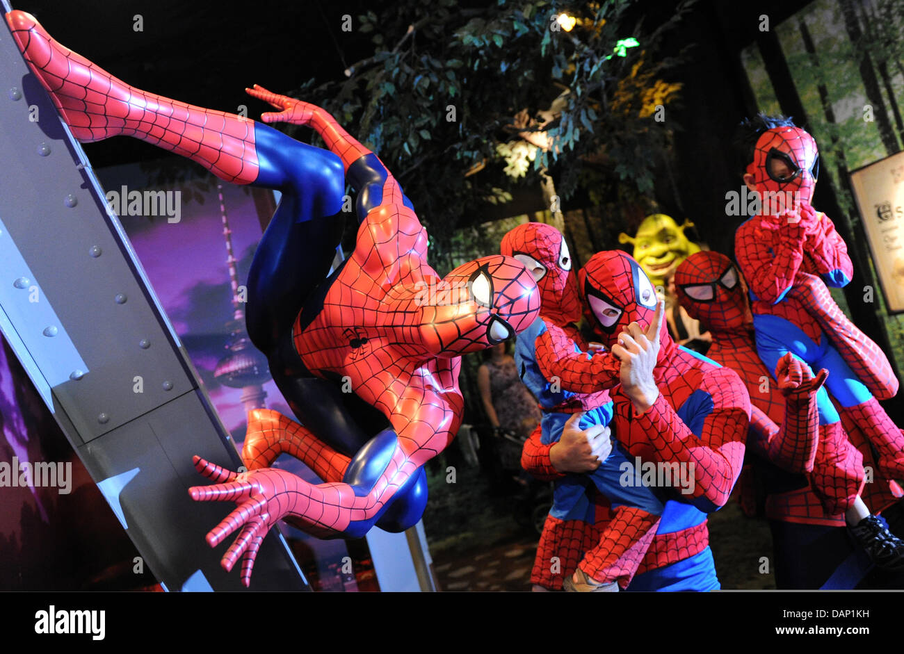 Fans als Spiderman verkleidet stellen neben einem Spider Man Figur bei Madame Tussauds Wachsfiguren-Museum in Berlin, Deutschland, 19. Juli 2011. Die Spinne Mann Wachsfigur ist ein neues Stück des Museums. Foto: JENS KALAENE Stockfoto