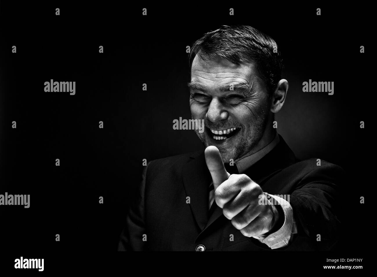 Reifer Mann Daumen auftauchend, Lächeln Stockfoto