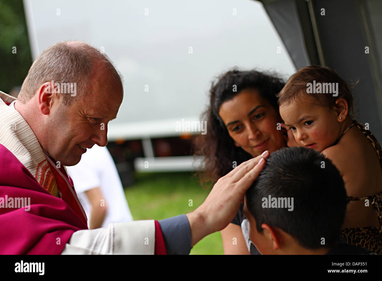 Propst Martin Tenge aus der Diözese Hildesheim segnet einen kleiner Junge in Germershausen, Deutschland, 21. Juli 2011. Mehrere hundert Sinti und Roma ein paar sammelten sich an einer Stelle der Pilgerfahrt in die katholische Kirche in Germershausen für die dritte internationale Pilgerfahrt der Sinti und Roma. Bis zum 24. Juli 2011 Pilger in der Kirche bleiben und feiern ein heiliges Marys Festiv Stockfoto