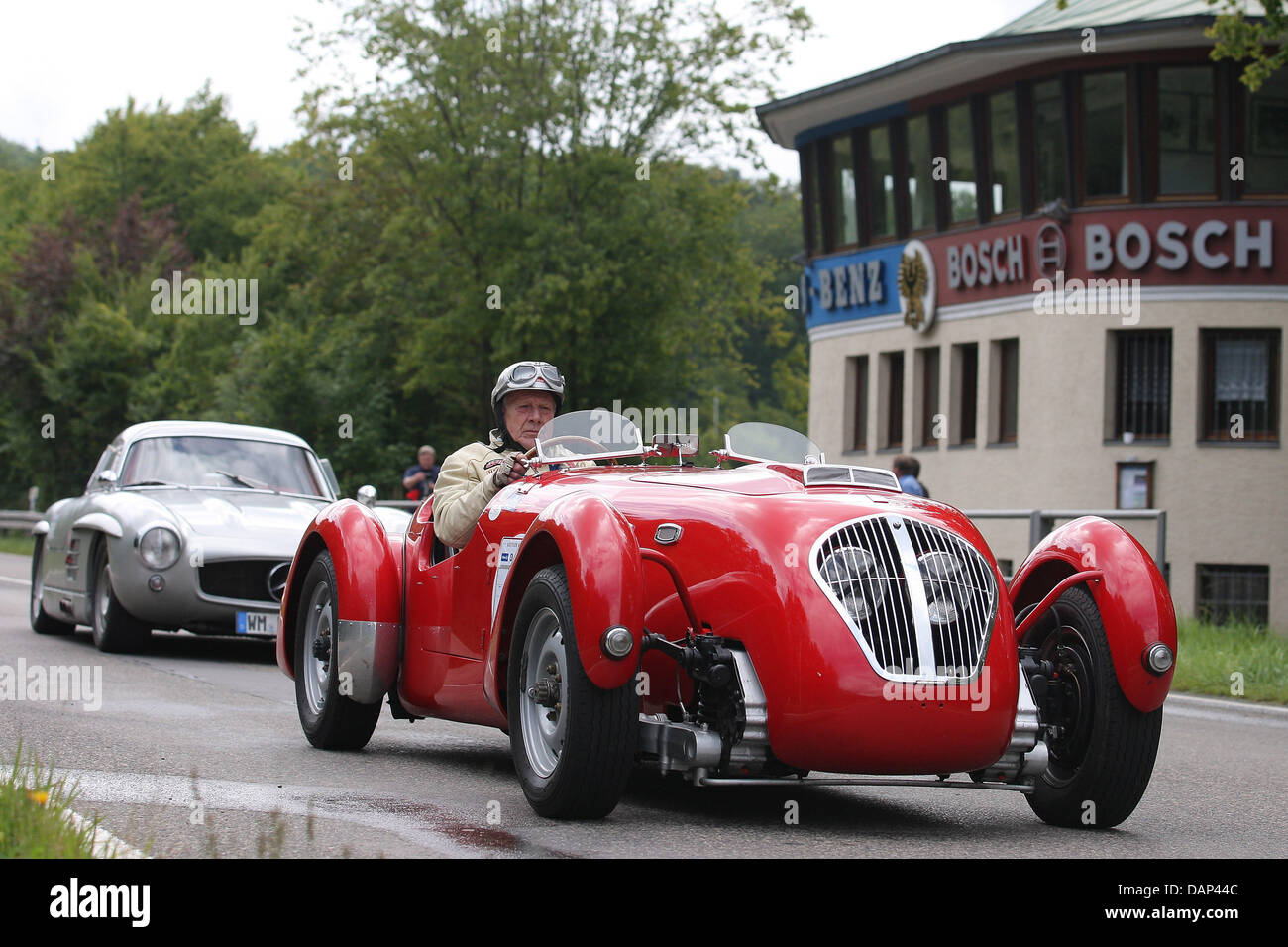 A Healey Silverstone Typ E (R) ab 1950 fährt auf die ehemalige Rennfahrer verfolgen Solitudering in der Nähe von Stuttgart, Deutschland, 23. Juli 2011. Die Rennstrecke ist seit 1965 nicht bestritten. Foto: THOMAS NIEDERMUELLER Stockfoto