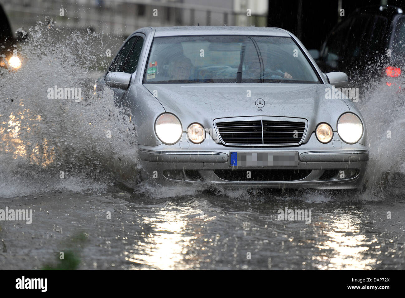 Ein Auto fährt durch eine überschwemmte Straße in Bochum, Deutschland, 28. Juli 2011. Foto: MARIUS BECKER Stockfoto