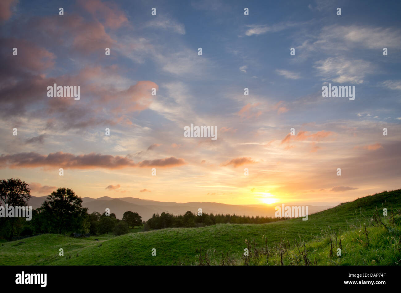 Tolle Farben in den Himmel und die Wolken die Sonne steigt in den Fjälls und grünen Hügeln des Lake District. Reine Sonnenaufgang Magie. Stockfoto