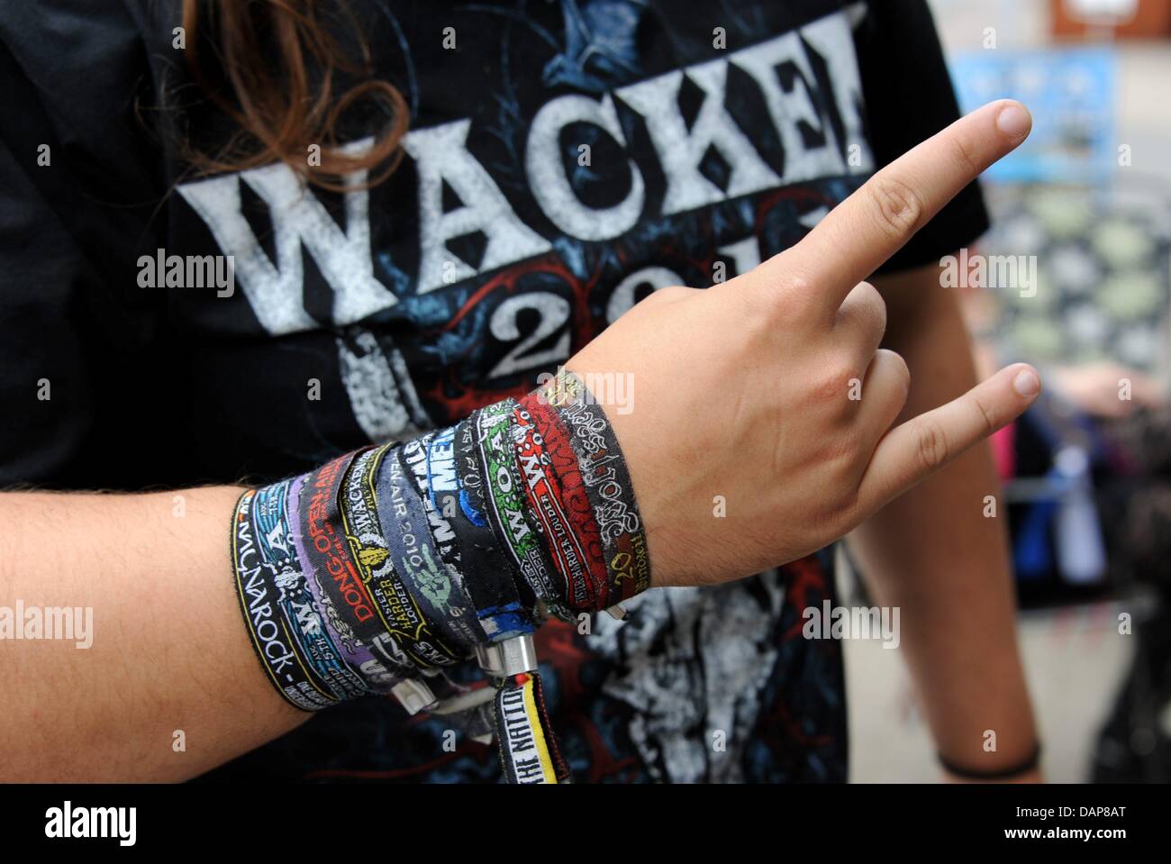 Ein HeavyMetalFan präsentiert seine Armbänder, erhielt er auf verschiedenen Festivals in Ein HeavyMetalFan präsentiert seine Armbänder, erhielt er auf verschiedenen Festivals in