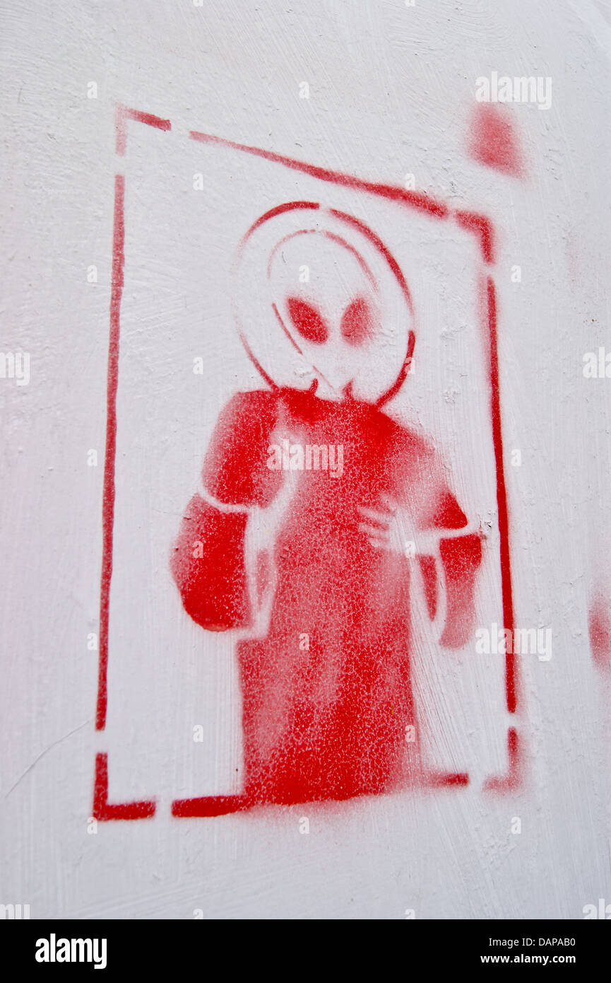 Sprühdose Graffiti eines roten space alien in einen Mantel auf einer weißen Wand gemalt Stockfoto