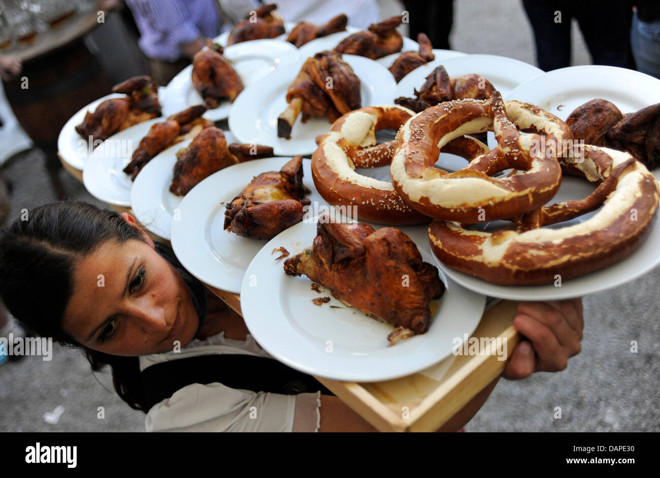 Eine Kellnerin trägt eine Tablette gestapelt mit Vollkornsemmeln und Rost Huhn auf dem Volksfest in Dachau, Deutschland, 13. August 2011. Zehntausende Besucher werden erwartet, die Veranstaltung zu besuchen, ist besonders bekannt für seine billige Bierpreise, die die niedrigsten Preise in Bayern gelten. Die Feierlichkeiten weiter bis zum 22 August. Foto: Andreas Gebert Stockfoto