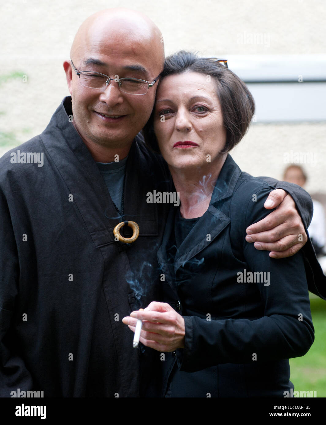 Chinesischer Dichter und Schriftsteller Liao Yiwu (L) und Rumänien geborene deutsche Nobel Preis Nobelpreisträger für Literatur Herta Mueller umarmen einander während einer Lesung in Berlin, Deutschland, 17. August 2011. Liao Yiwu stellte sein neuestes Buch "Mein Zeugnis" in Deutschland. Foto: Jörg Carstensen Stockfoto