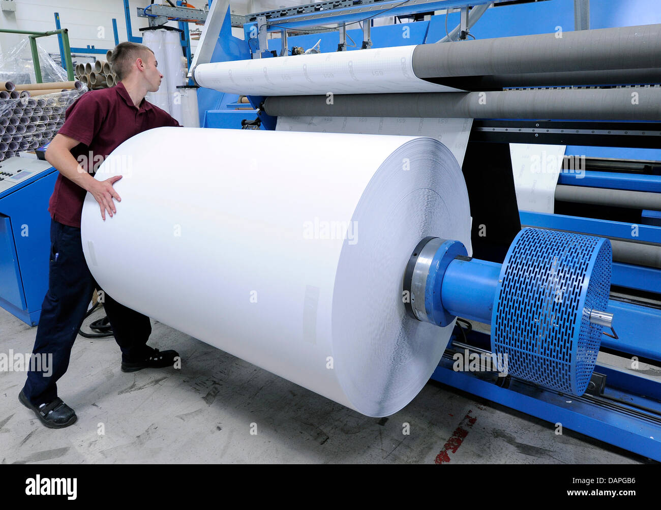 Ein Orafol Europe Mitarbeiter arbeitet auf einer Schneidemaschine für  Folien am Produktionsstandort in Oranienburg, Deutschland, 10. August 2011.  Das Unternehmen mit 602 Mitarbeitern produziert selbstklebende Folien, hohe  Persistenz Folien und ...