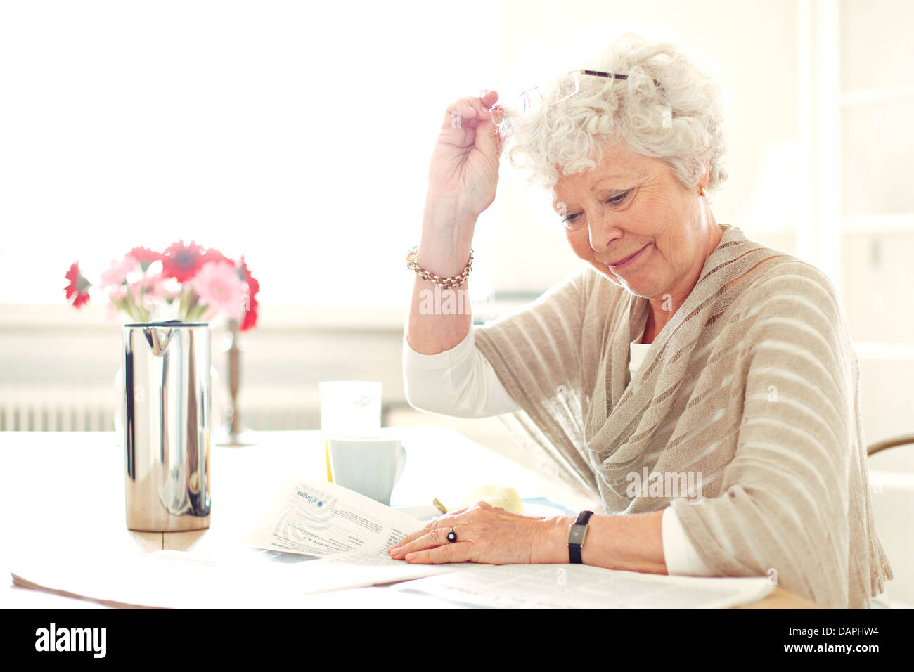 Oma zu Hause beschäftigt, etwas zu lesen Stockfoto