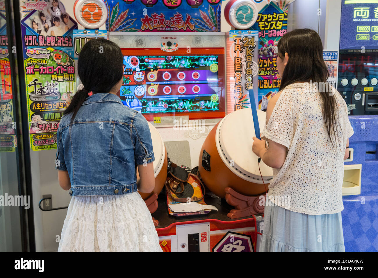 Mädchen im Teenageralter Taiko keine Tatsujin Rhythmus Drum Spiel spielen, Kagoshima, Japan Stockfoto