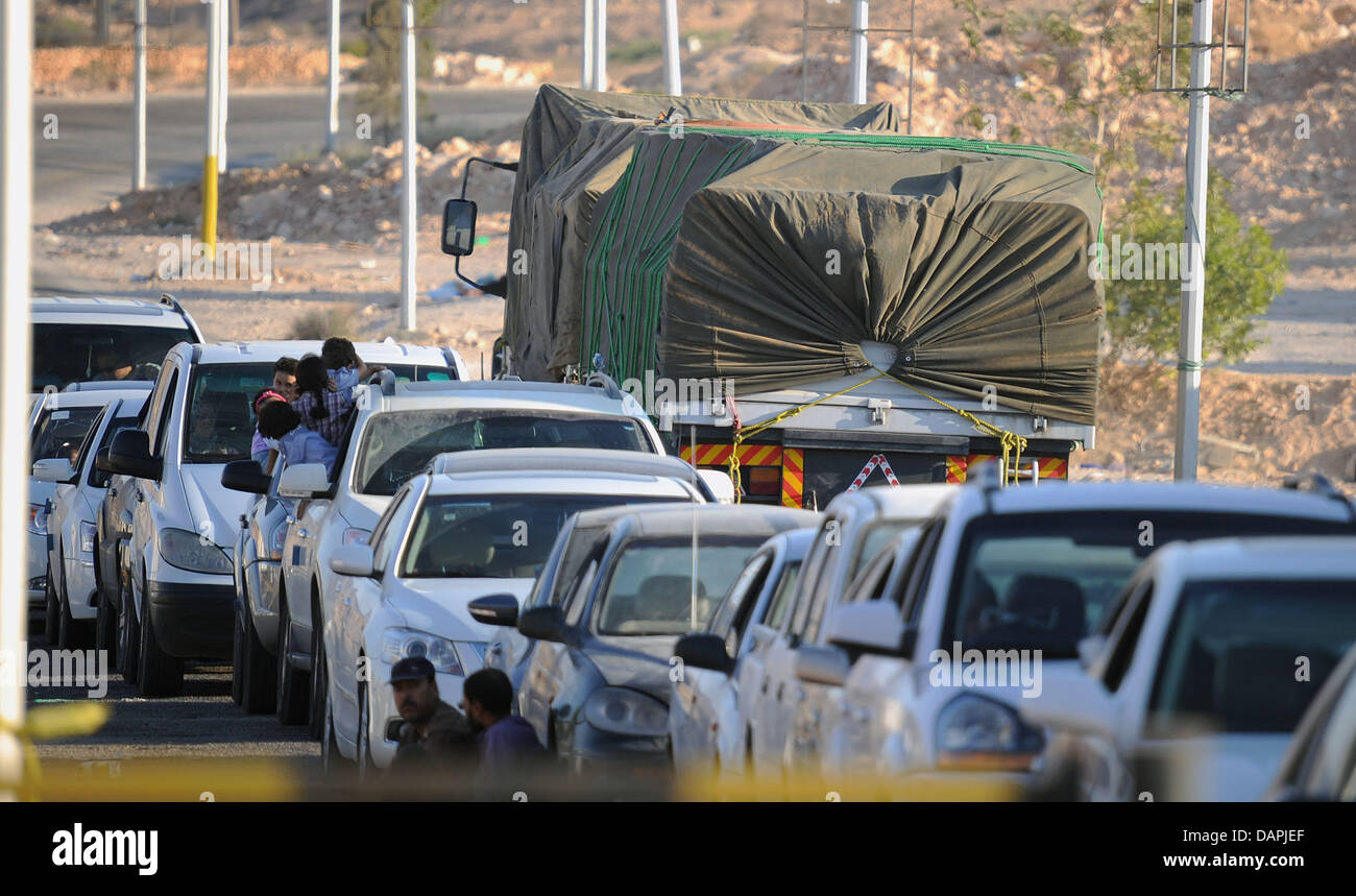 Autos sitzen an der tunesisch-libyschen Grenze in Dahibah, Tunesien, 23. August 2011. Viele wollen Libyen laut ausländische Nachrichten Sender, Rebellen überlassen und Gaddafi Faithfuls haben kämpften erbittert um die schwer befestigte Residenz des Diktators Muammar al-Gaddafi in der libyschen Hauptstadt nehmen. Entsprechend ihrer eigenen Konten erweiterte Rebellen auf die fast sechs Quadratkilometer großen zusammengesetzten Stockfoto