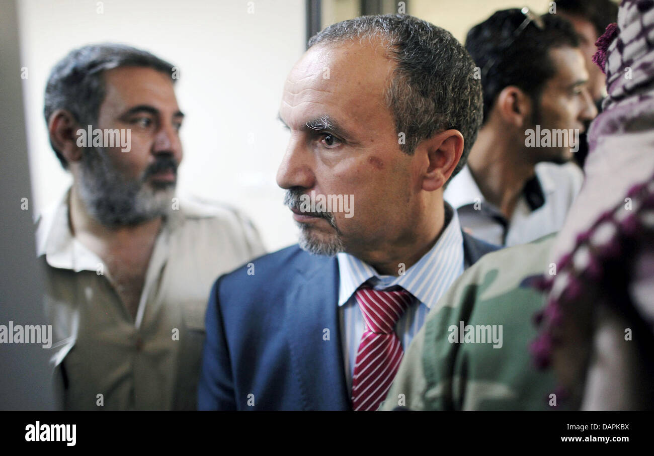 Naji Barakat (C), kommt Mitglied des Vorstands von der Transitional National Rat (TNC) - die libyschen Rebellen Regierung-in-Waiting - auf Donnerstag, 25. August 2011 im Gebäude der ehemaligen Öl-Ministerium in Tripoli, Libyen. Naji Barakat ist die TNC Vorstand verantwortlich für die Gesundheit. Rebellen-Kämpfer loyal zu Gaddafi noch Donnerstag stießen in der Nähe von den libyschen Stockfoto