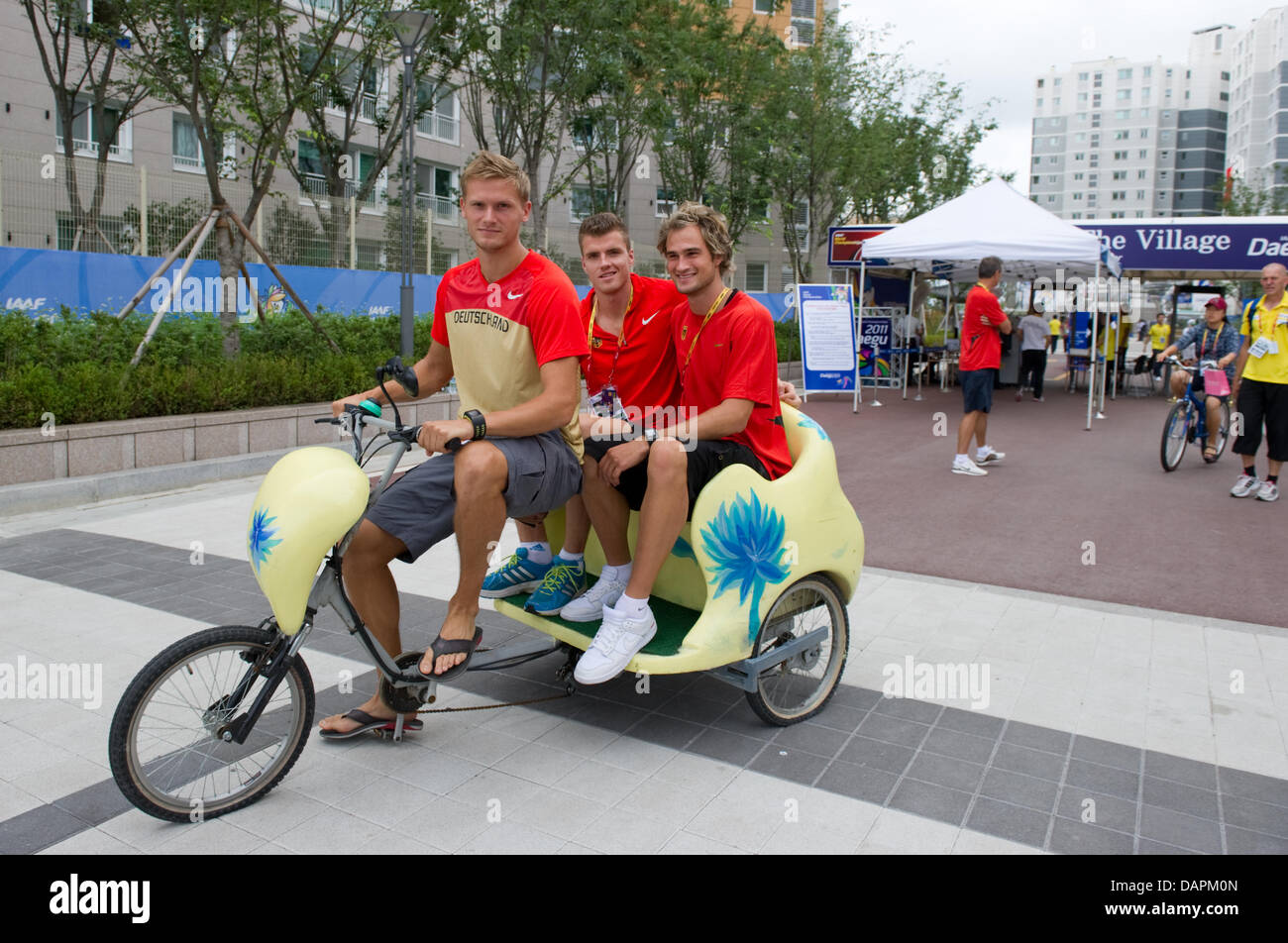 Deutsche Zehnkämpfer Pascal Behrenbruch, Rico Freimuth und Jan Felix Knobel (L-R) übernehmen eine Fahrradtour mit einer Rikscha vor den Athleten Dorf in Daegu, Südkorea, 26. August 2011. Die 2011 beginnt am 27. August 2011 IAAF World Championships. Foto: Bernd Thissen dpa Stockfoto