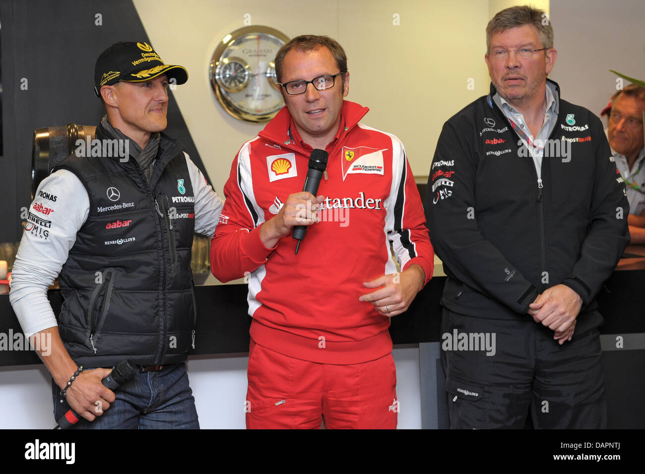 Italienischen Stefano Domenicali (M), Team-Manager von Ferrari und Englisch Ross Brawn, Teammanager des Mercedes GP mit einer Dankesrede an deutsche Formel1 Rennfahrer Michael Schumacher Mercedes GP an seinem Geburtstag im Mercedes GP Wohnmobil am Circuit de Spa-Francorchamps in der Nähe von Spa, Belgien, 27. August 2011. Bei der belgischen GP 1991 fuhr Michael Schumacher seine erste für Stockfoto
