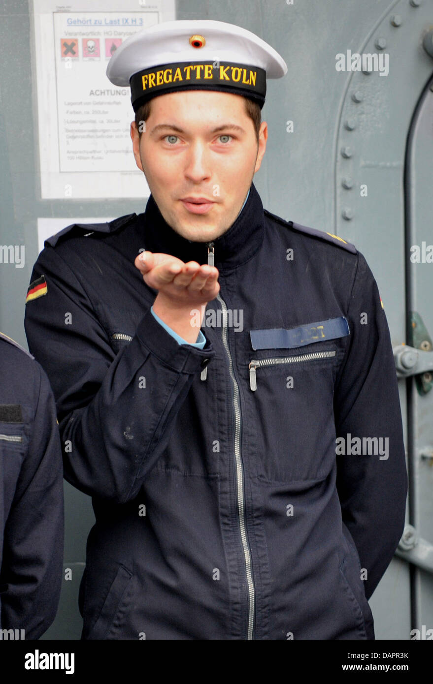 Bootsmann Kumpel bläst (Oberbootsmaat) Frank M. einen Kuss zu seiner Freundin während der Fregatte "Köln" Abfahrten aus dem Marinestützpunkt in Wilhelmshaven, Deutschland, 29. August 2011. Das deutsche Marineschiff nimmt Kurs auf zur Teilnahme an der Anti-Piraten-Operation "Atalanta" am Horn von Afrika. Foto: CARMEN JASPERSEN Stockfoto