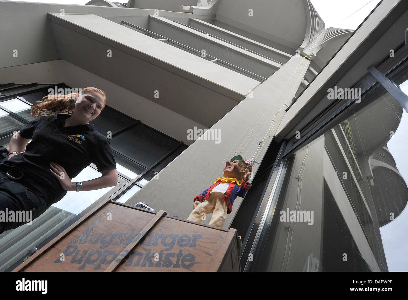 Melanie Marschall steht neben den Stempel in der Hotel Tower in Augsburg, Deutschland, 2. September 2011. Anlässlich des zehnten Geburtstags von der Puppentheater-Museum tanzten der Stempel nach unten das höchste Gebäude in Augsburg, die 100 Meter hat. Die Puppe sollte den Rekord für den Betrieb einer Marionette vom höchsten Punkt gesetzt haben. Foto: STEFAN PUCHNER Stockfoto