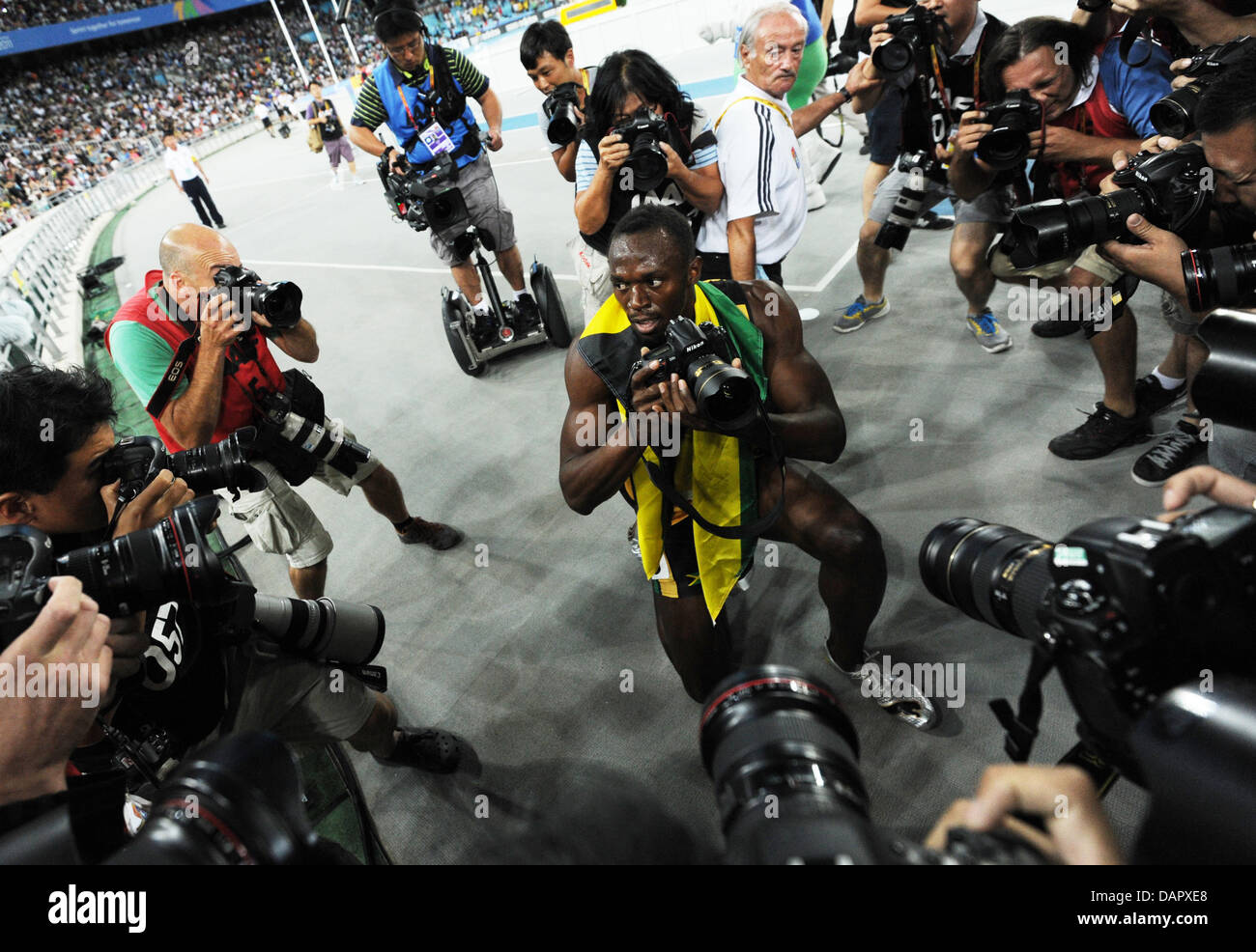 Usain Bolt (C) von Jamaika nimmt ein Bild mit einem Fotografen Kamera nach dem Sieg in der Herren, 200 Meter Finale bei der 13. IAAF Weltmeisterschaften in Daegu, Südkorea, 3. September 2011. Foto: Rainer Jensen dpa Stockfoto
