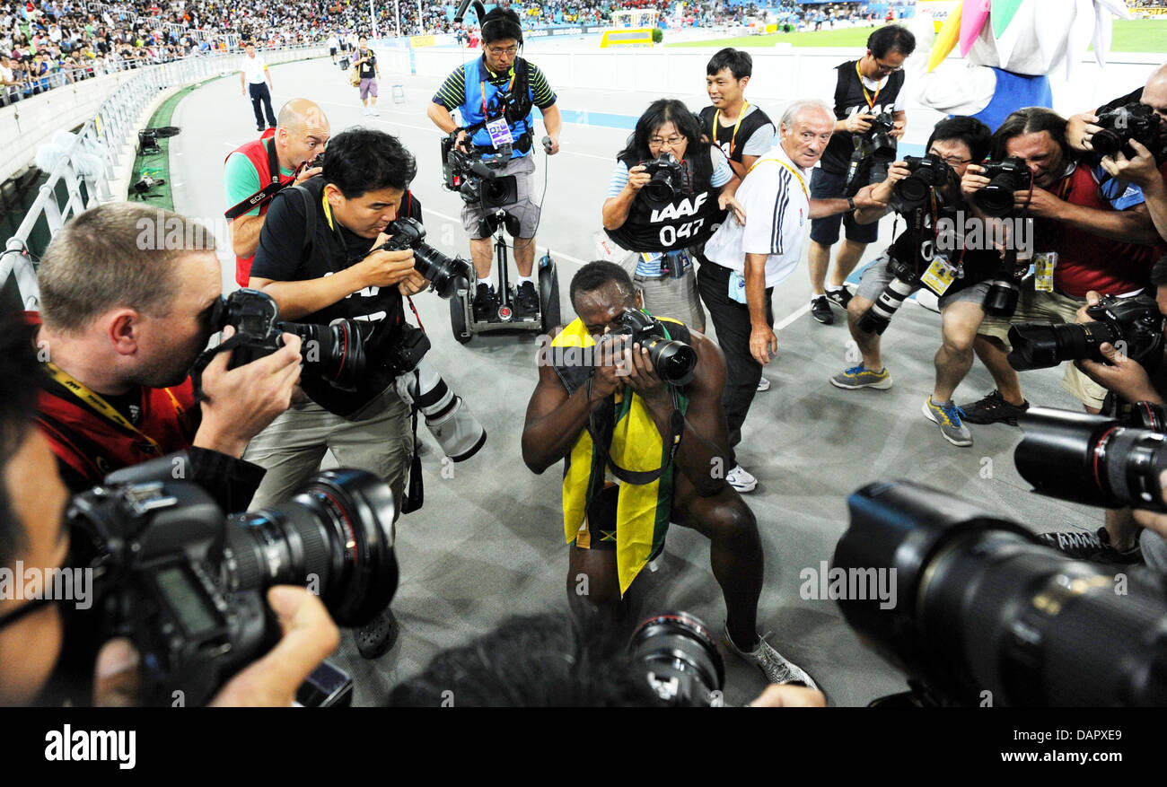 Usain Bolt (C) von Jamaika nimmt ein Bild mit einem Fotografen Kamera nach dem Sieg in der Herren, 200 Meter Finale bei der 13. IAAF Weltmeisterschaften in Daegu, Südkorea, 3. September 2011. Foto: Rainer Jensen Dpa +++(c) Dpa - Bildfunk +++ Stockfoto