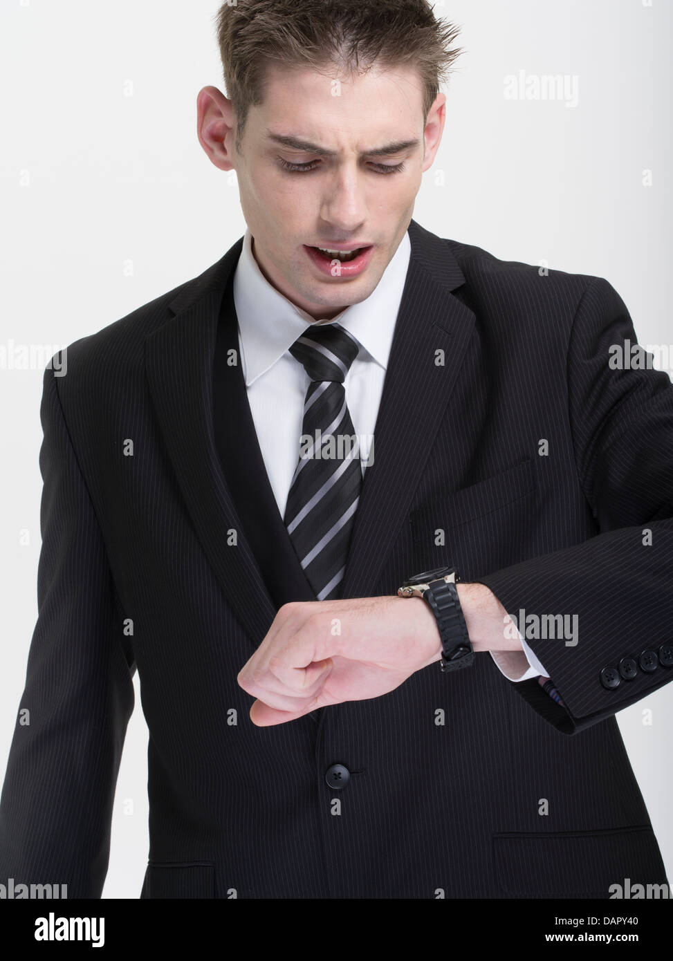 Geschäftsmann in Anzug und Krawatte spät dran, prüft seine Uhr Stockfoto